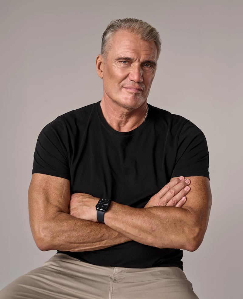 Dolph Lundgren sitting with arms crossed